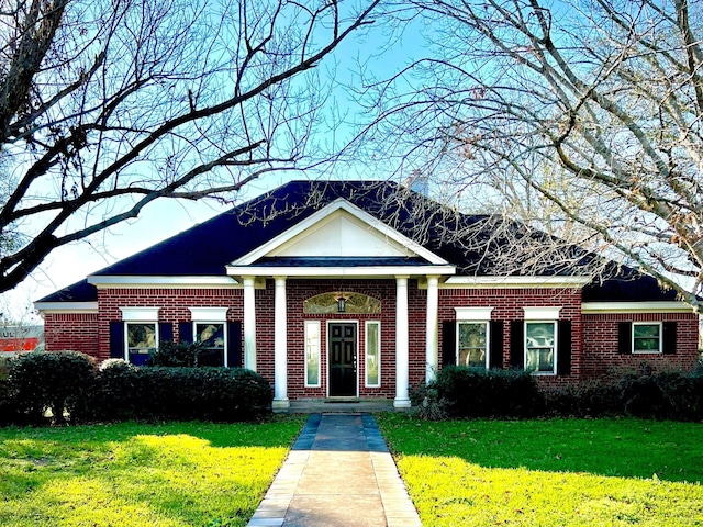 greek revival house with a front lawn and brick siding