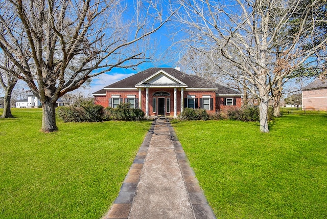 greek revival house with brick siding and a front lawn