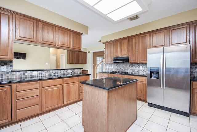 kitchen with visible vents, under cabinet range hood, stainless steel fridge with ice dispenser, and light tile patterned flooring