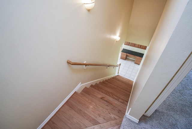 stairway featuring baseboards and wood finished floors