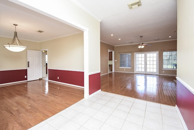 spare room featuring ornamental molding, wood finished floors, and visible vents