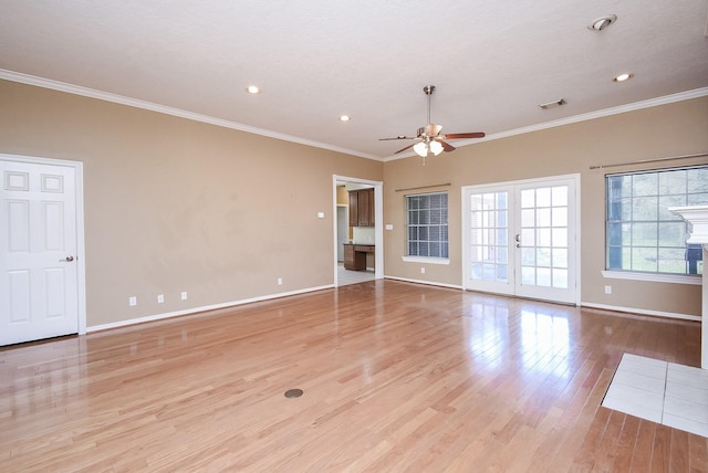 unfurnished room featuring french doors, visible vents, light wood-style flooring, ornamental molding, and baseboards