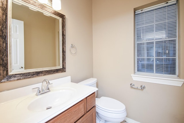 half bathroom featuring vanity and toilet