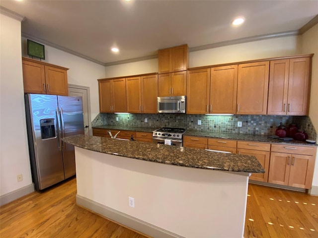 kitchen with stainless steel appliances, ornamental molding, and light wood finished floors