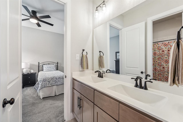 bathroom featuring ceiling fan, double vanity, ensuite bath, and a sink