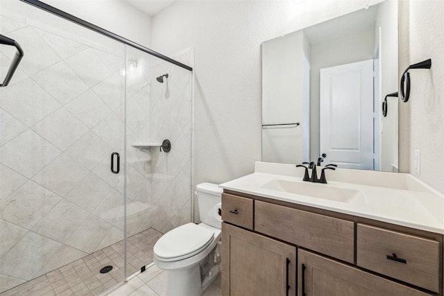 bathroom featuring a shower stall, toilet, and vanity