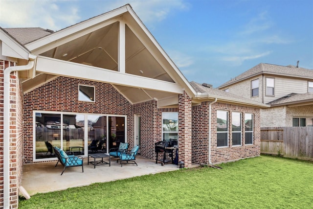 back of property featuring a patio area, brick siding, fence, and a lawn