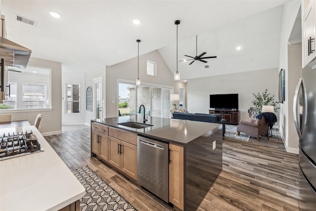 kitchen featuring visible vents, dark countertops, appliances with stainless steel finishes, dark wood-type flooring, and a sink