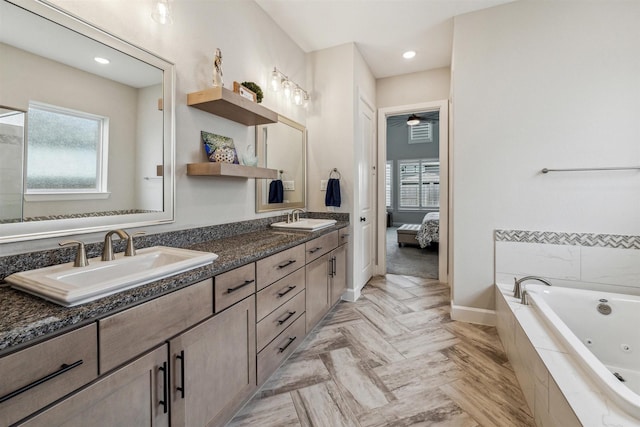 ensuite bathroom featuring a whirlpool tub, ensuite bath, double vanity, and a sink