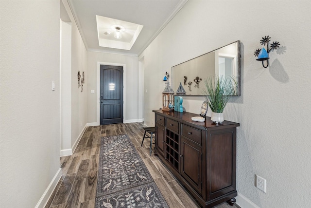 doorway to outside with wood tiled floor, ornamental molding, a raised ceiling, and baseboards