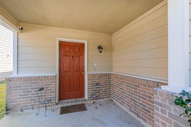 view of exterior entry featuring brick siding