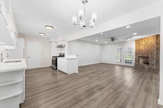 kitchen with ceiling fan, a sink, white cabinets, open floor plan, and gas stove