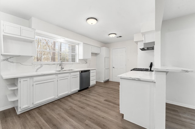 kitchen with white cabinets, a sink, wood finished floors, a peninsula, and dishwashing machine