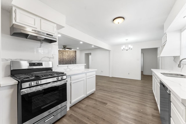 kitchen with appliances with stainless steel finishes, white cabinets, a sink, and under cabinet range hood