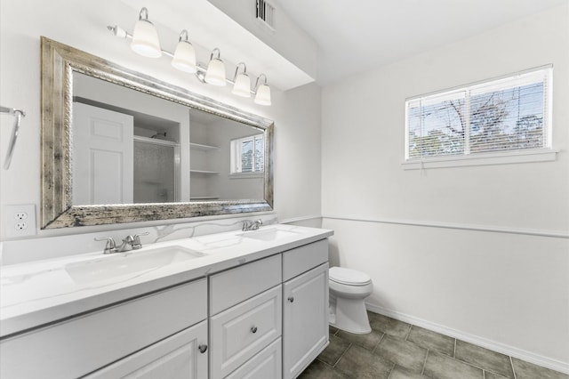 bathroom with toilet, a sink, visible vents, a shower stall, and double vanity