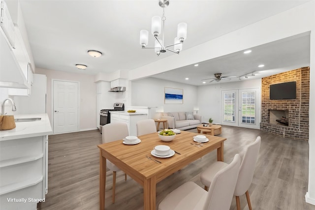 dining area featuring ceiling fan, light wood-style flooring, recessed lighting, a fireplace, and baseboards