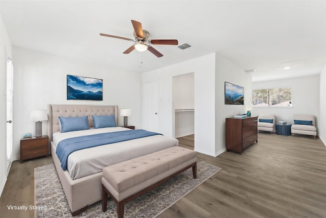 bedroom featuring baseboards, ceiling fan, visible vents, and wood finished floors