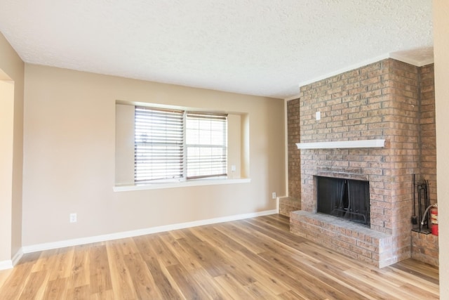 unfurnished living room featuring a textured ceiling, a fireplace, and wood finished floors