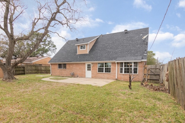 rear view of property featuring a fenced backyard, brick siding, roof with shingles, a lawn, and a patio area