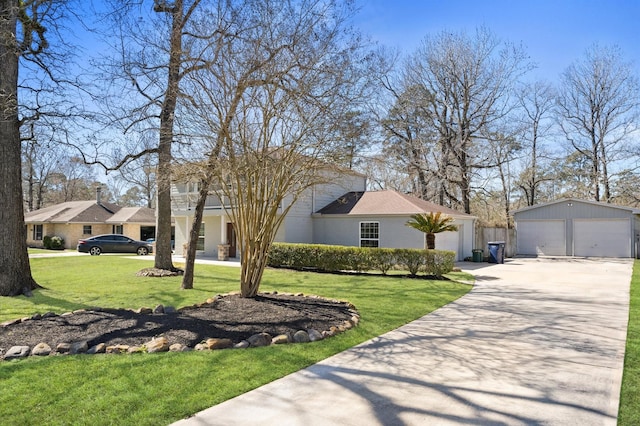 view of front of property featuring a detached garage, an outbuilding, and a front yard