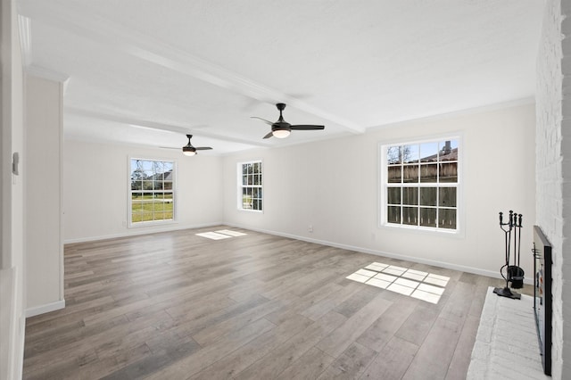 unfurnished living room with a brick fireplace, baseboards, and wood finished floors