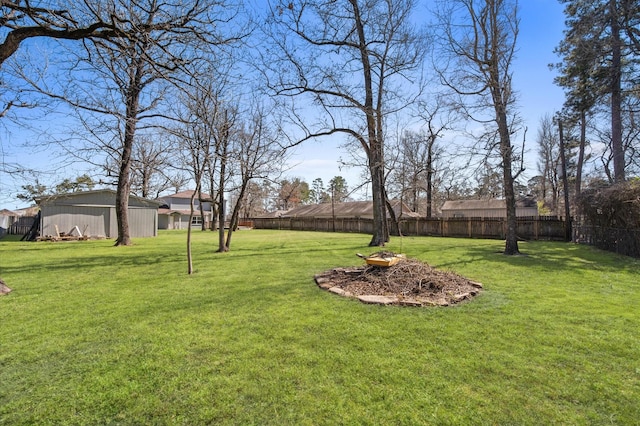 view of yard featuring fence and an outbuilding