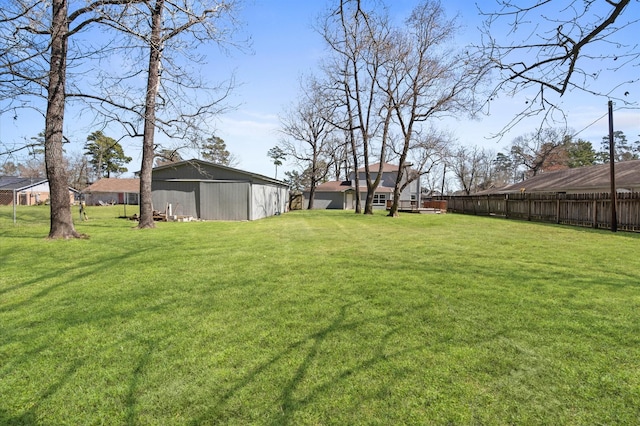 view of yard featuring a pole building, an outdoor structure, and fence