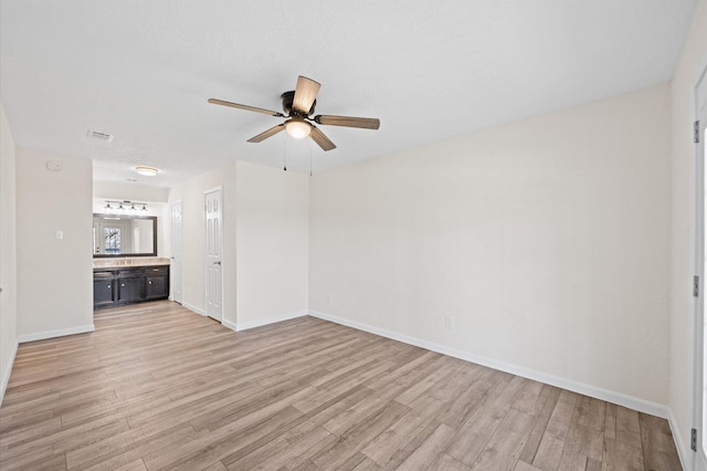 unfurnished living room with light wood-style floors, visible vents, ceiling fan, and baseboards