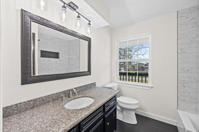 bathroom with baseboards, toilet, a tile shower, a textured ceiling, and vanity