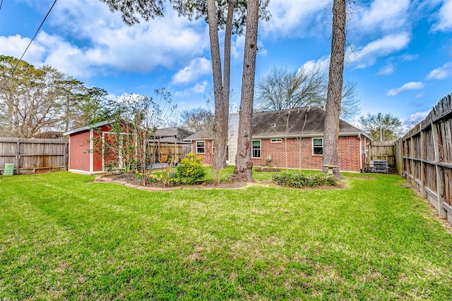 view of yard featuring a storage unit, an outdoor structure, and a fenced backyard