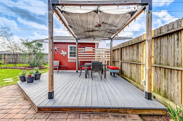 wooden deck featuring outdoor dining area and a fenced backyard