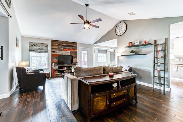 living area with visible vents, wood finished floors, a ceiling fan, and vaulted ceiling