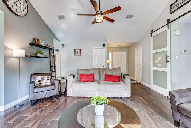 living room featuring a barn door, visible vents, and wood tiled floor