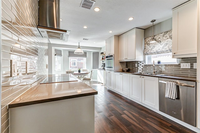 kitchen featuring visible vents, a sink, decorative backsplash, dark wood-type flooring, and appliances with stainless steel finishes