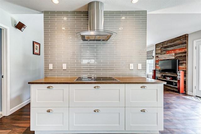 kitchen with black electric stovetop, butcher block countertops, dark wood finished floors, and wall chimney range hood