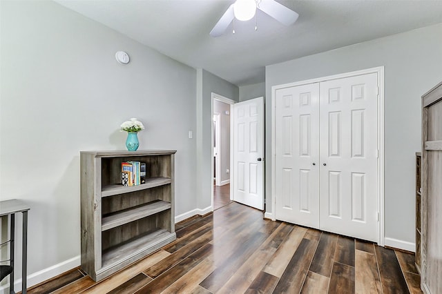 bedroom featuring dark wood-type flooring, baseboards, and a closet