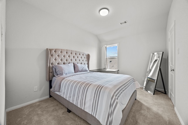 carpeted bedroom with lofted ceiling, baseboards, and visible vents