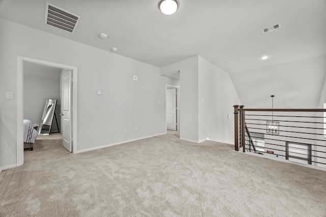 empty room featuring vaulted ceiling, carpet floors, visible vents, and baseboards