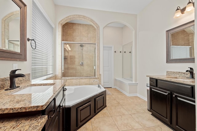 full bath featuring a stall shower, a sink, a bath, and tile patterned floors