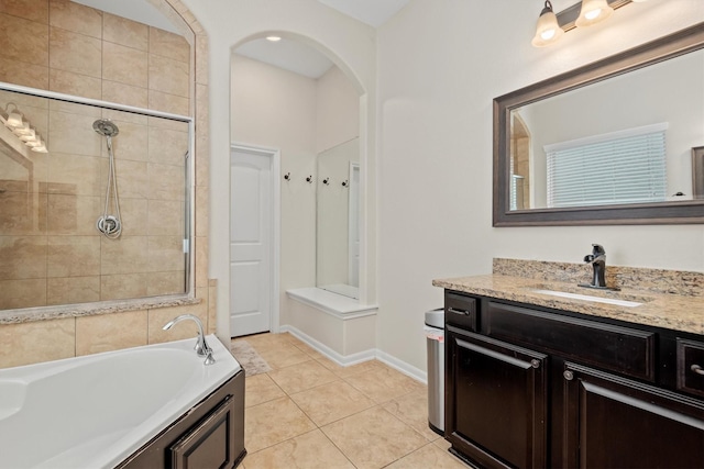 full bathroom featuring a garden tub, a tile shower, vanity, baseboards, and tile patterned floors