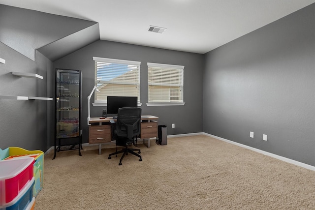 carpeted home office with vaulted ceiling, visible vents, and baseboards