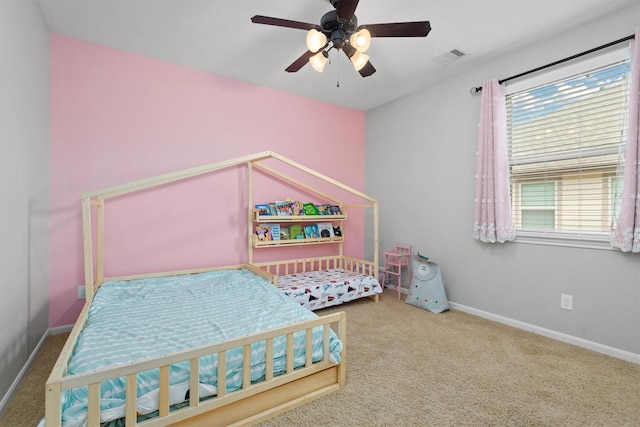 carpeted bedroom with a ceiling fan, visible vents, and baseboards