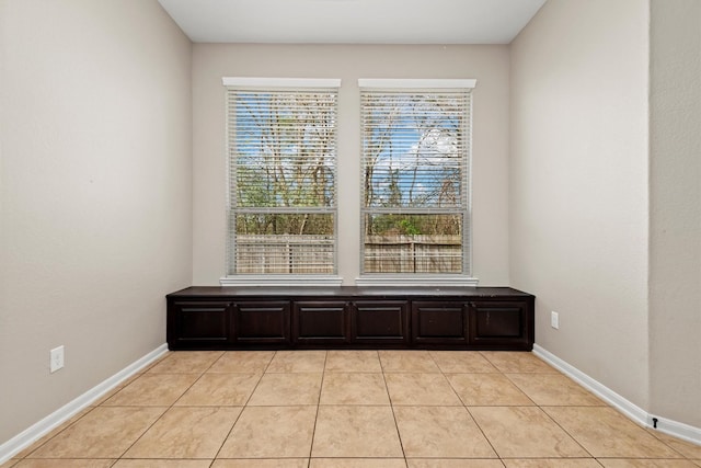 unfurnished room featuring light tile patterned flooring and baseboards