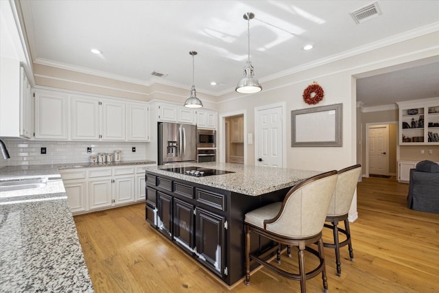 kitchen featuring visible vents, white cabinets, stainless steel appliances, and a sink