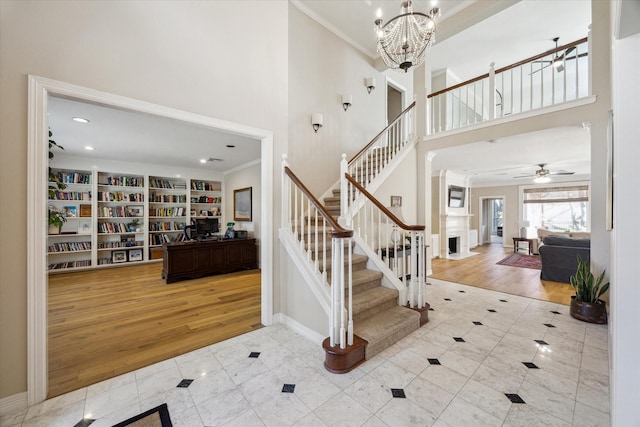 foyer featuring stairway, crown molding, a high ceiling, and wood finished floors