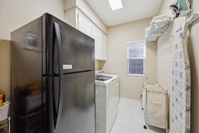 laundry area with separate washer and dryer, light tile patterned floors, cabinet space, and baseboards