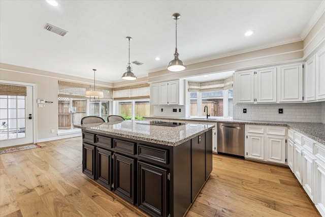 kitchen with stainless steel dishwasher, white cabinets, and visible vents