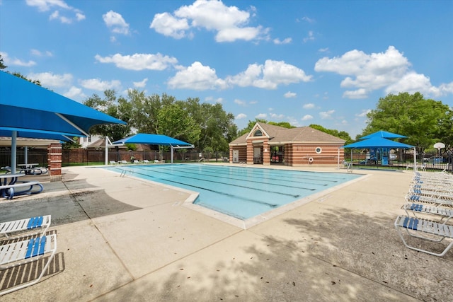 pool with a patio and fence