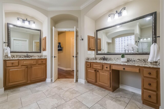 full bathroom with ornamental molding, vanity, and baseboards