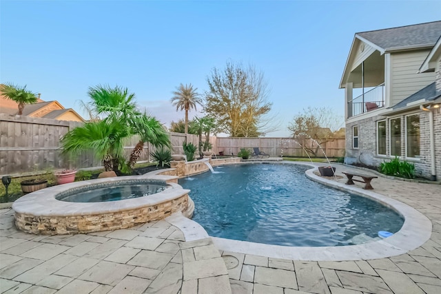 view of pool featuring a patio, a fenced backyard, and a pool with connected hot tub